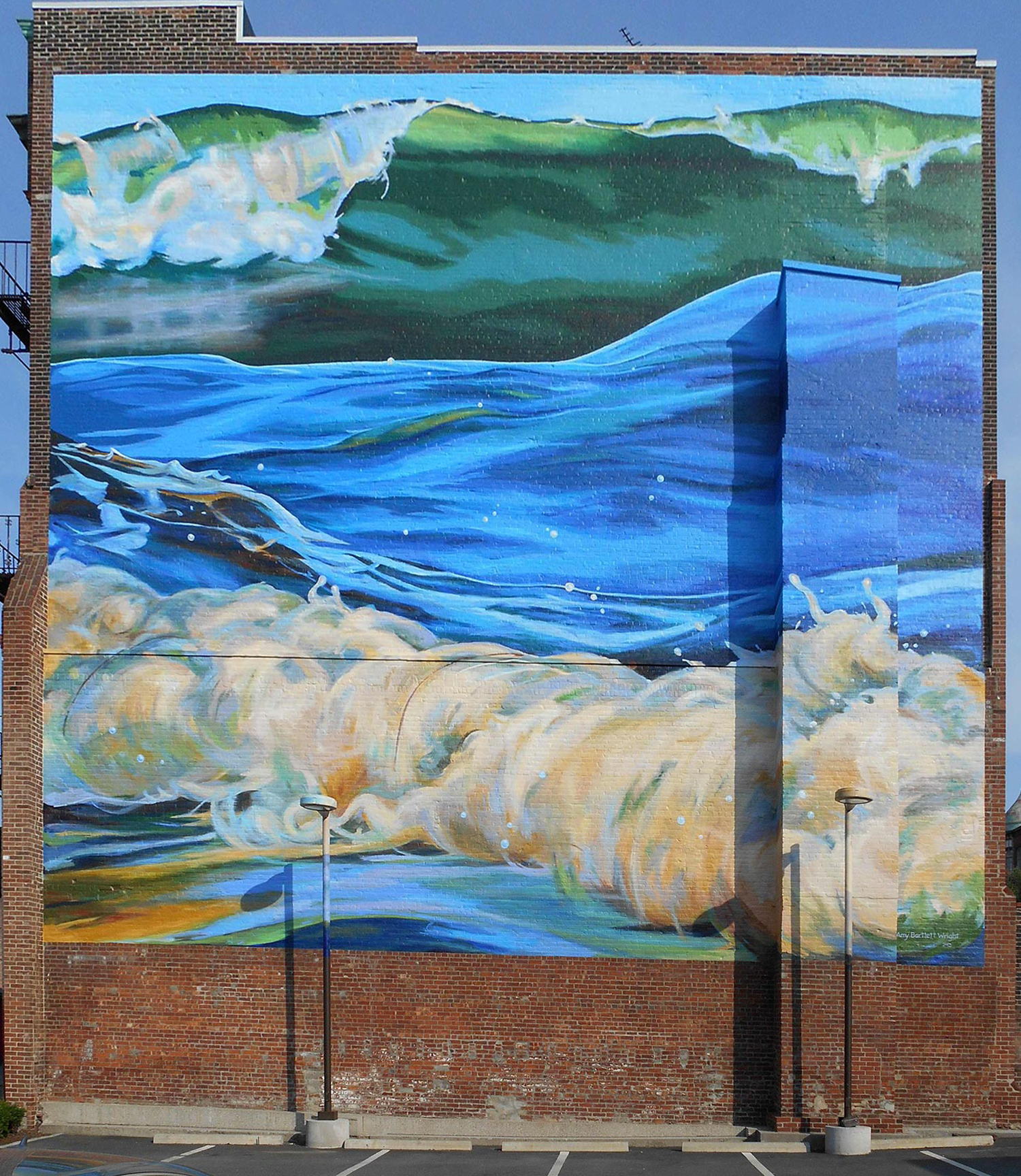mural showing three ocean waves painted on a brick wall